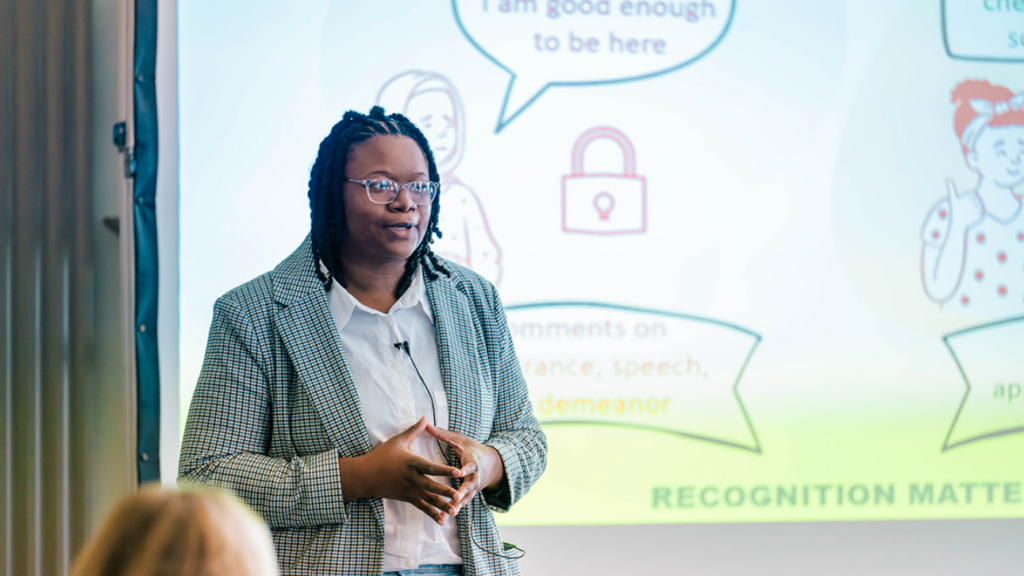 Individual in a checked blazer participating in the three-minute thesis competition